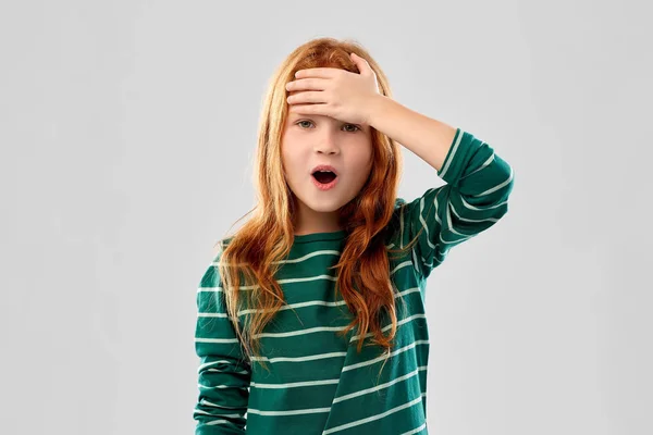 Shocked red haired girl holding to her head — стоковое фото