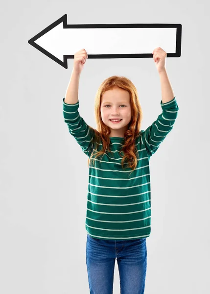 Sorrindo menina de cabelos vermelhos com seta mostrando à esquerda — Fotografia de Stock