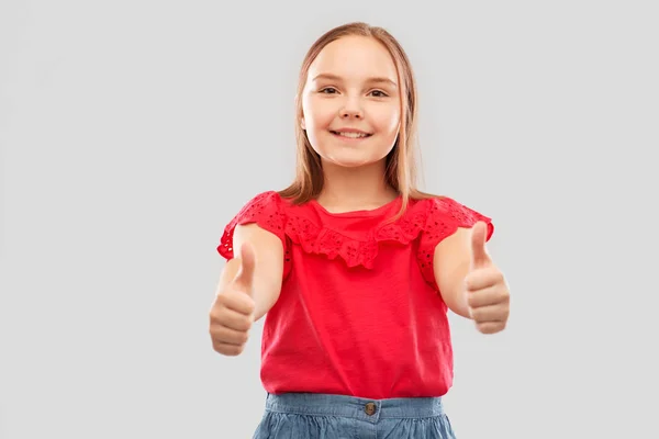 Krásná usměvavá dívka ukazuje palec — Stock fotografie