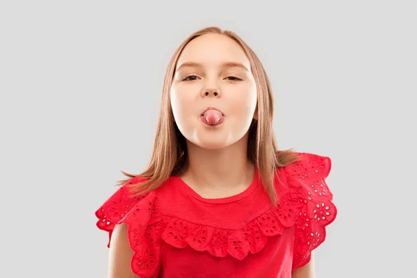 Hermosa chica en camisa roja mostrando su lengua — Foto de Stock