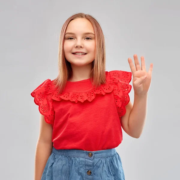 Menina sorridente em camisa vermelha mostrando quatro dedos — Fotografia de Stock