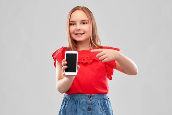 Schönes lächelndes Mädchen zeigt Smartphone — Stockfoto