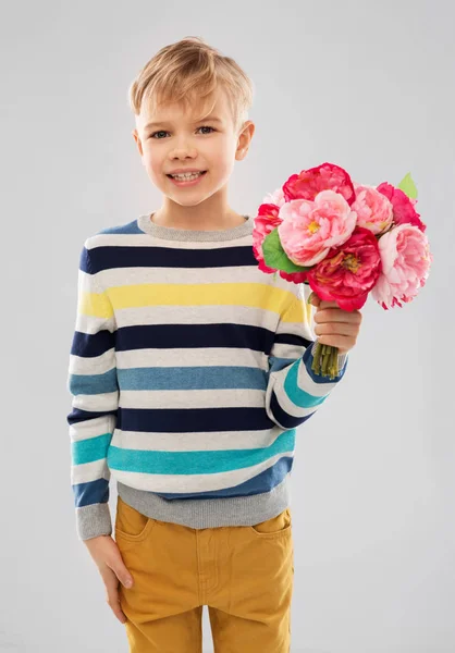 Leende pojke med gäng pion blommor — Stockfoto