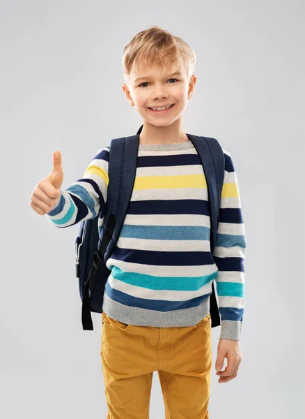 Estudiante chico con escuela bolsa mostrando pulgares arriba —  Fotos de Stock