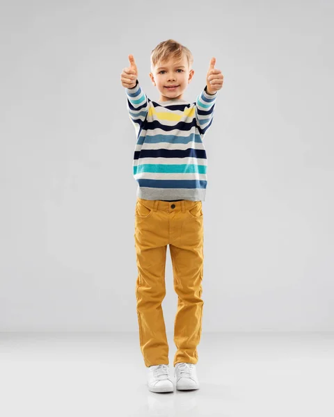 Sorridente ragazzo a strisce pullover mostrando pollici in su — Foto Stock