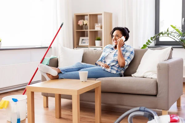 Mulher chamando no smartphone após a limpeza em casa — Fotografia de Stock