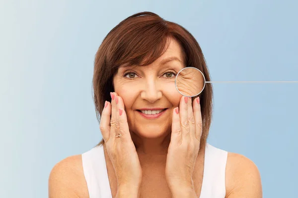 Senior Kvinna med zoomat öga rynkor i pekare — Stockfoto