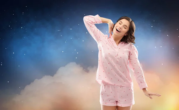 Happy woman in pajama stretching over night sky — ストック写真