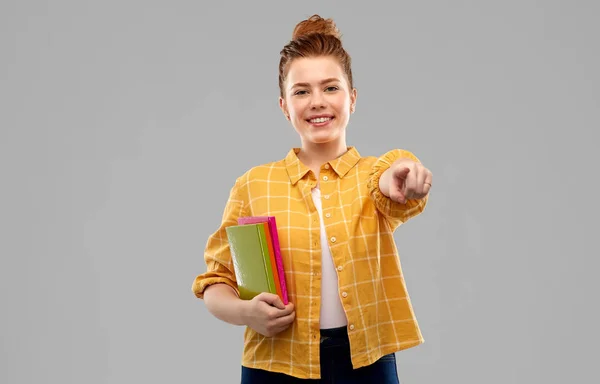 Adolescente estudiante con libros que apuntan a usted — Foto de Stock