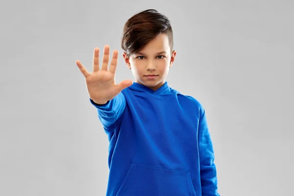 Fiú-ban kék kapucnis pulcsit gyártás megállás gesztus — Stock Fotó