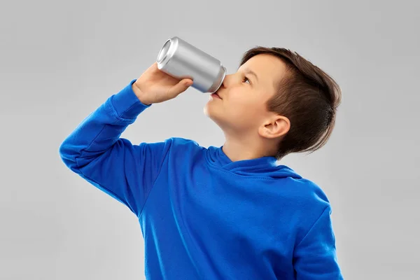 Boy in blue hoodie drinking soda from tin can — Stock Photo, Image