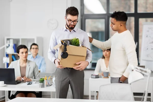 Collega vedendo fuori triste licenziato lavoratore d'ufficio maschile — Foto Stock