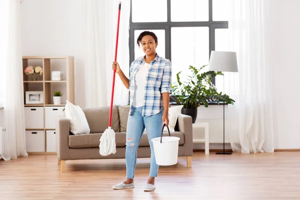 Afrikaanse vrouw of huisvrouw schoonmaken vloer thuis — Stockfoto