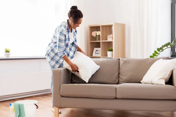 Африканская американка раскладывает диванные подушки — стоковое фото
