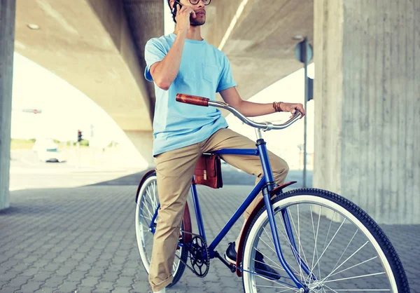 Hombre con teléfono inteligente y bicicleta de engranaje fijo en la calle — Foto de Stock