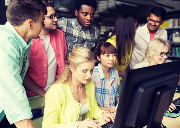 Estudantes internacionais com computadores na biblioteca — Fotografia de Stock