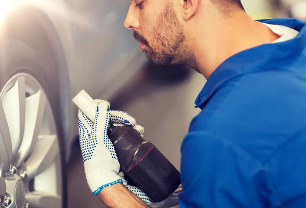 Mechaniker mit Schraubenzieher wechselt Autoreifen — Stockfoto