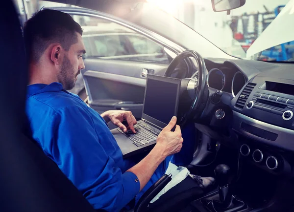 Homem mecânico com laptop fazendo o diagnóstico do carro — Fotografia de Stock