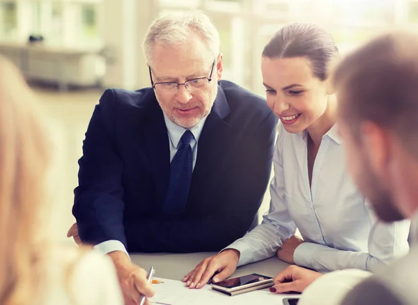 Architects with smartphone and blueprint at office — Stock Photo, Image