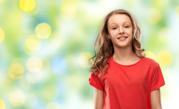 Mladá dívka v červeném tričku nad zelenými světly — Stock fotografie