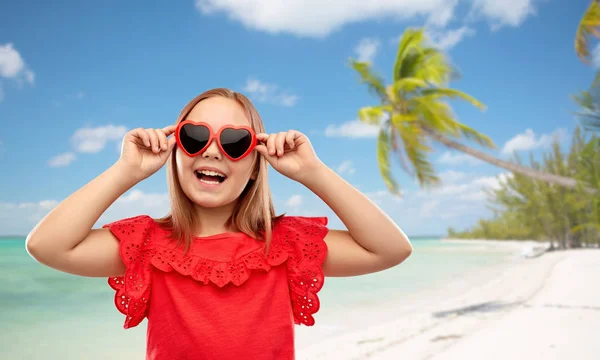 Sahilde kalp şeklinde güneş gözlüğü ile mutlu kız — Stok fotoğraf