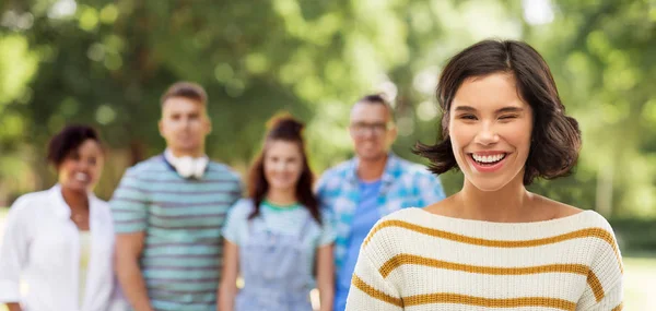 Mulher feliz piscando no parque de verão com amigos Fotos De Bancos De Imagens Sem Royalties