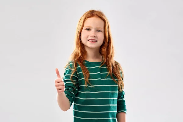 Usmívající se rudovlasá dívka ukazující palce — Stock fotografie