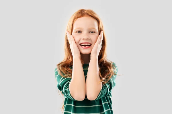 Sorrindo menina de cabelos vermelhos em camisa listrada — Fotografia de Stock