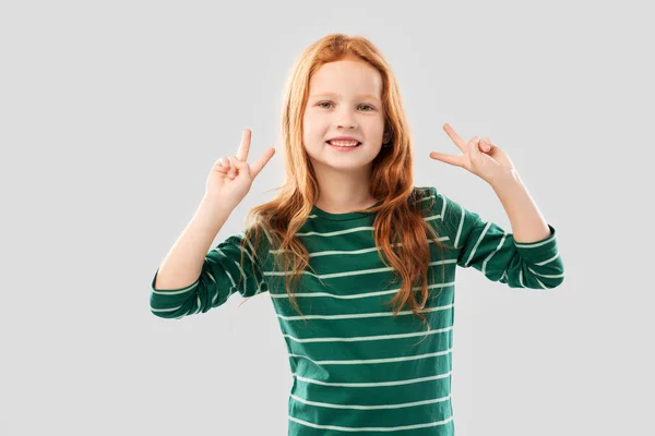 Sorrindo menina de cabelos vermelhos mostrando gesto de paz — Fotografia de Stock