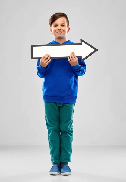 Boy holding big white rightwards thick arrow — Stock Photo, Image