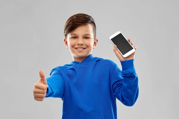 Sorrindo menino mostrando smartphone e polegares para cima — Fotografia de Stock