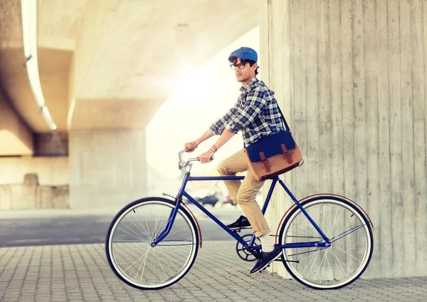 Mladý hipster muž s taškou na koni pevné kolo — Stock fotografie