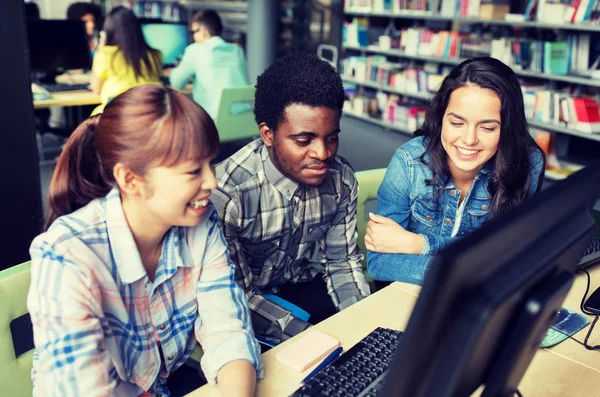 Internationale Studenten mit Computern in der Bibliothek — Stockfoto