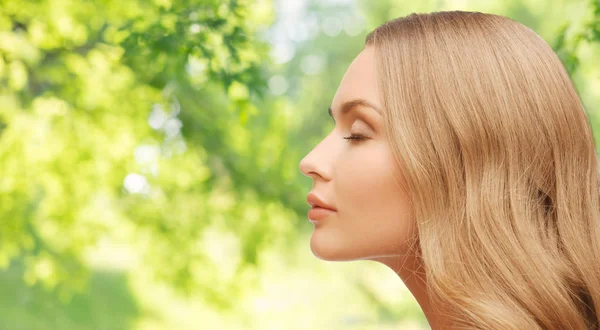 Beautiful young woman face over natural background — Stock Photo, Image