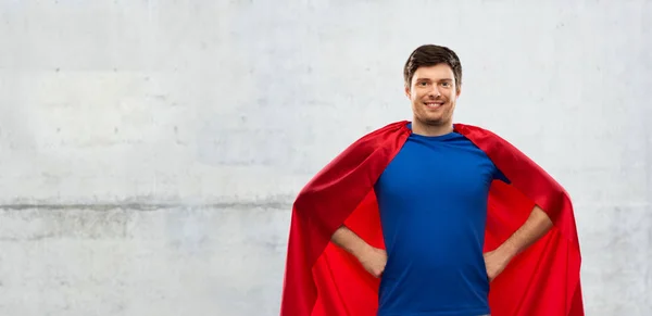 Hombre en capa de superhéroe rojo sobre fondo de hormigón — Foto de Stock