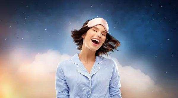 Happy young woman in pajama and eye sleeping mask — Stock Photo, Image