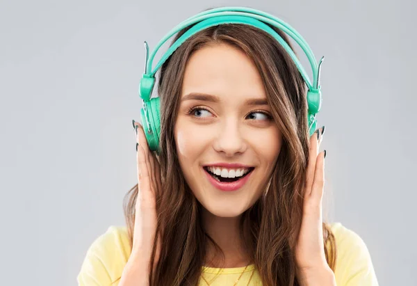 Glad ung kvinna eller tonårsflicka med hörlurar — Stockfoto
