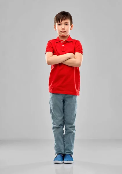 Niño triste en camiseta de polo rojo con brazos cruzados — Foto de Stock