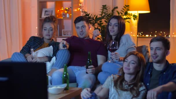 Vrienden met dranken en snacks thuis tv-kijken — Stockvideo