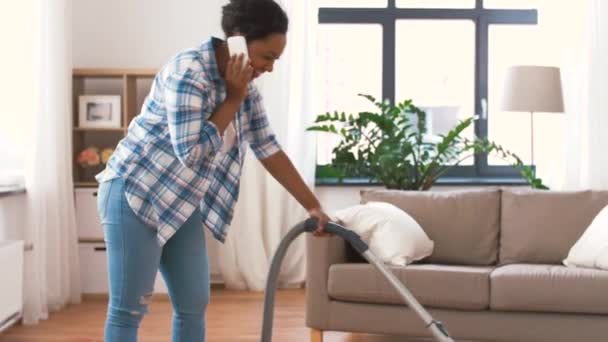 African american woman with vacuum cleaner at home — Stock Video