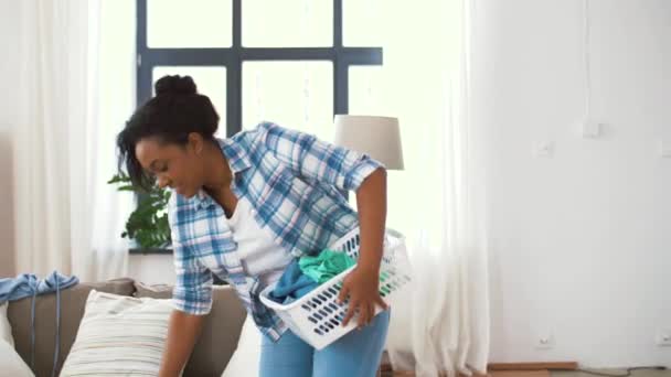 Szczęśliwa kobieta zbieranie ubrań do prania w domu — Wideo stockowe