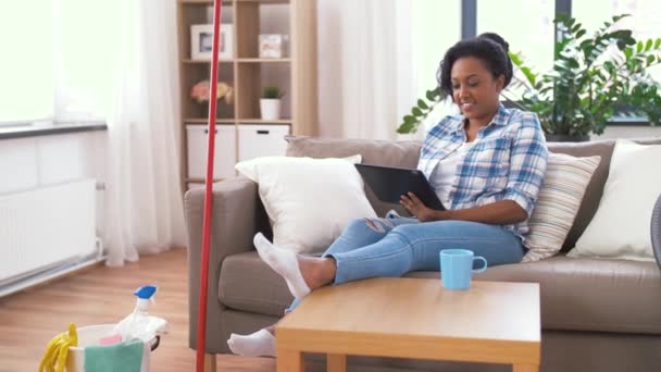 Mulher com tablet pc descansando após a limpeza em casa — Vídeo de Stock