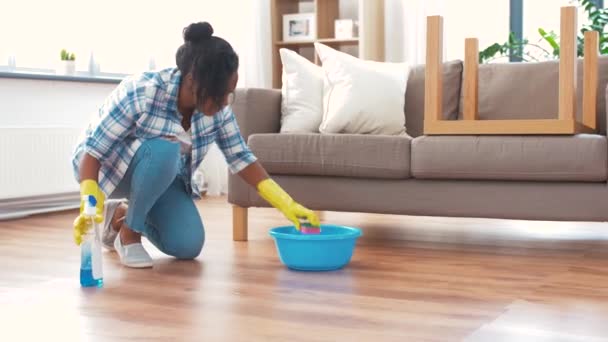 Afrikansk kvinna med svamp rengöring golv hemma — Stockvideo