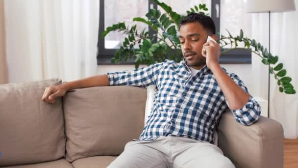 Hombre que llama en el teléfono inteligente después de limpiar casa — Vídeos de Stock