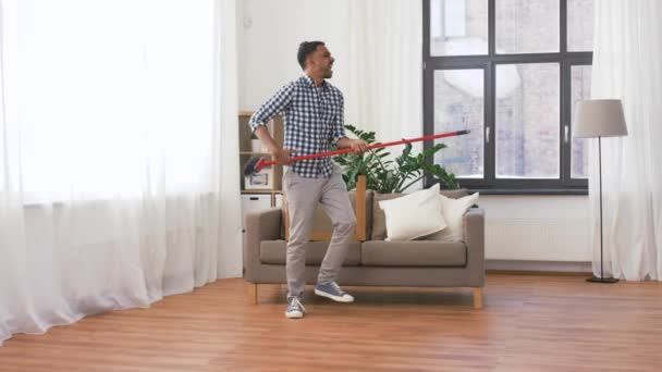 Hombre con escoba limpieza y divertirse en casa — Vídeo de stock