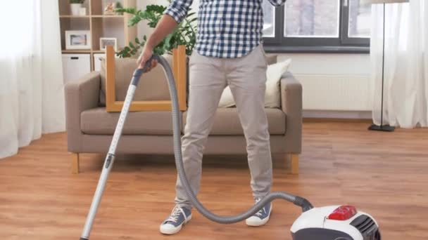 Man with vacuum cleaner calling on cell at home — Stock Video