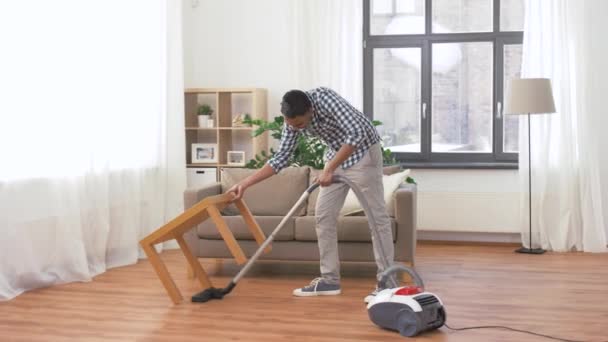 Человек с пылесосом дома — стоковое видео