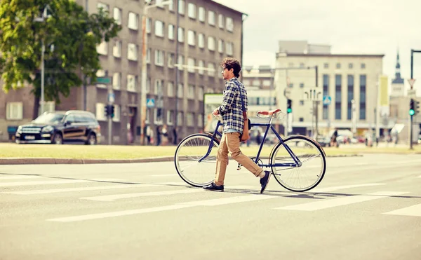 Joven con bicicleta de engranaje fijo en el paso de peatones —  Fotos de Stock