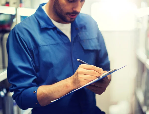 Auto mechanic with clipboard at car workshop — Stock Photo, Image