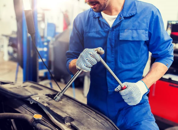Mekaniker man med skiftnyckel reparera bil på verkstaden — Stockfoto